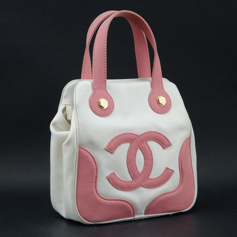 Chanel Pink & White Canvas Tote. Matte gold hardware, "Chanel" fabric interior with zipper pocket. Labeled appropriately. 