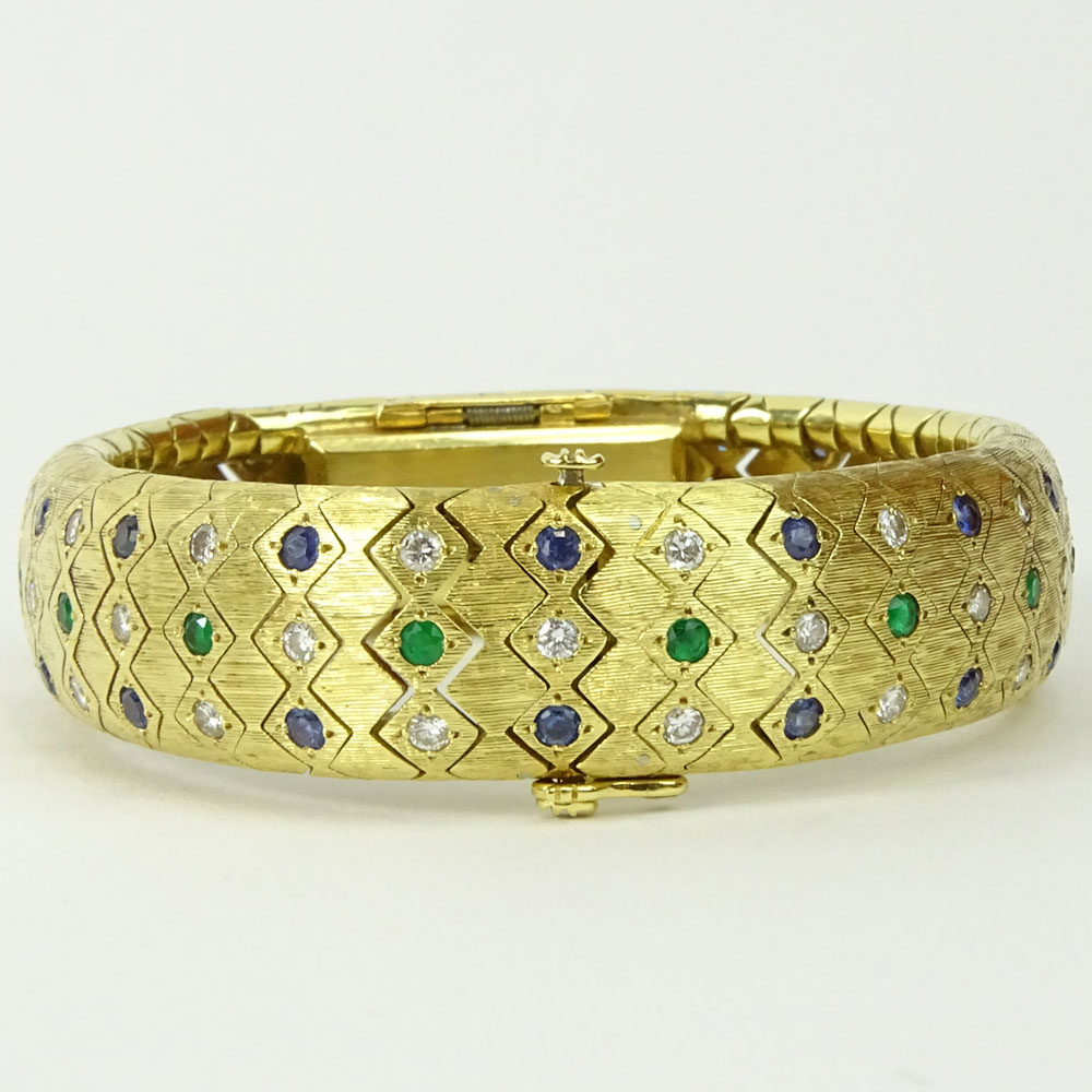 Lady's Vintage 18 Karat Yellow Gold Flexible Link Bangle Bracelet Manual Movement Watch set throughout with Round Cut Diamonds, Sapphires and Emeralds.