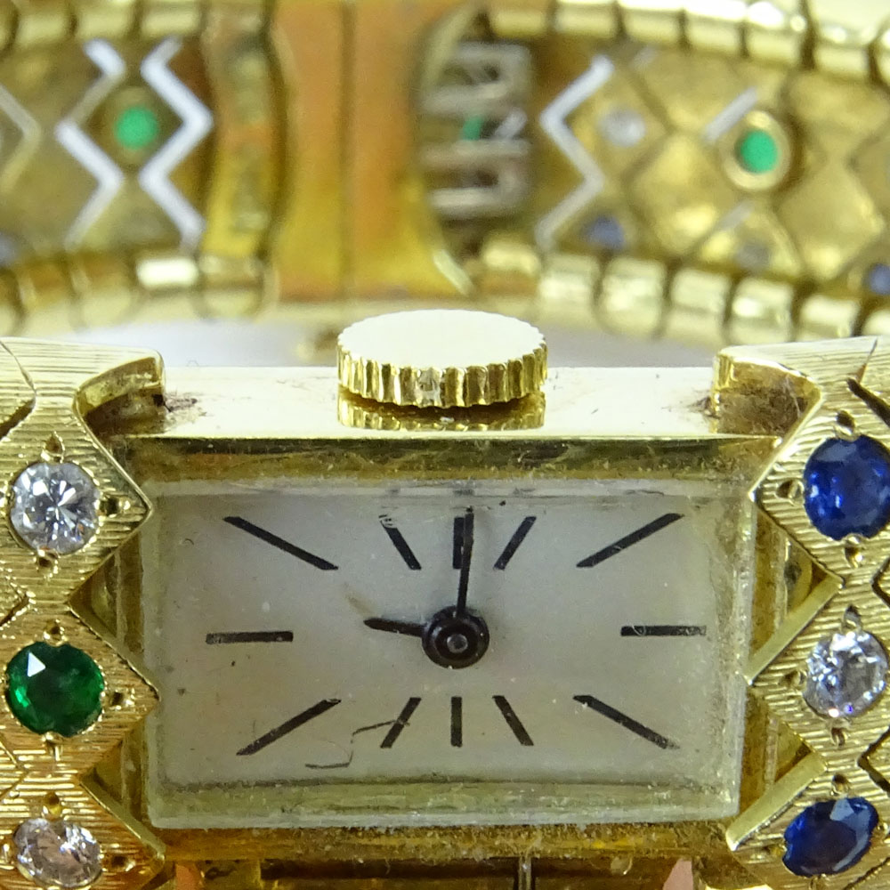 Lady's Vintage 18 Karat Yellow Gold Flexible Link Bangle Bracelet Manual Movement Watch set throughout with Round Cut Diamonds, Sapphires and Emeralds.