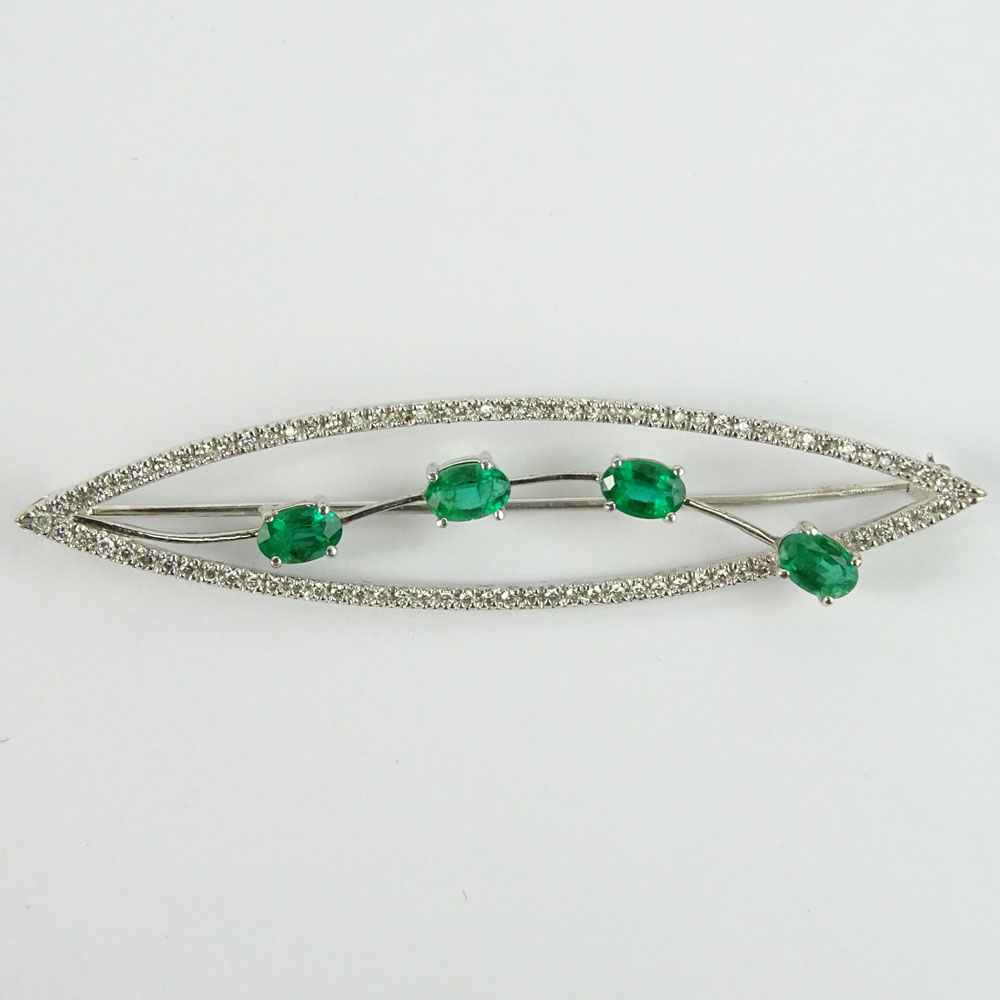 Lady's Vintage Oval Cut Emerald and 14 Karat White Gold Brooch accented throughout with Small Round Cut Diamonds.