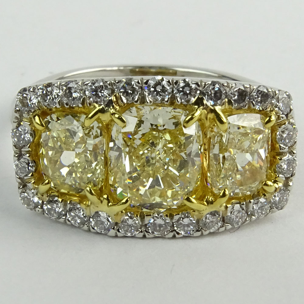 Approx. 3.0 Carat Cushion Cut Fancy Yellow Diamond, Platinum and 18 Karat Yellow Gold Three Stone Ring.