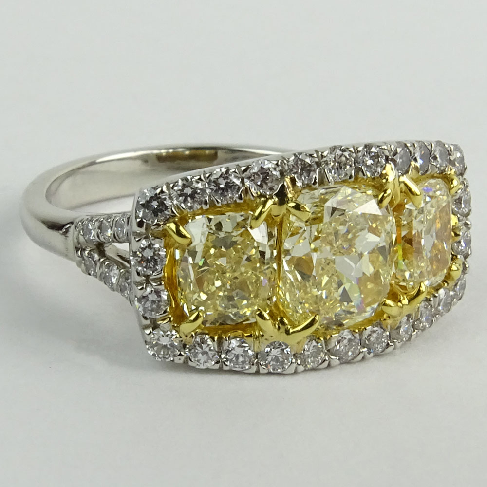 Approx. 3.0 Carat Cushion Cut Fancy Yellow Diamond, Platinum and 18 Karat Yellow Gold Three Stone Ring.