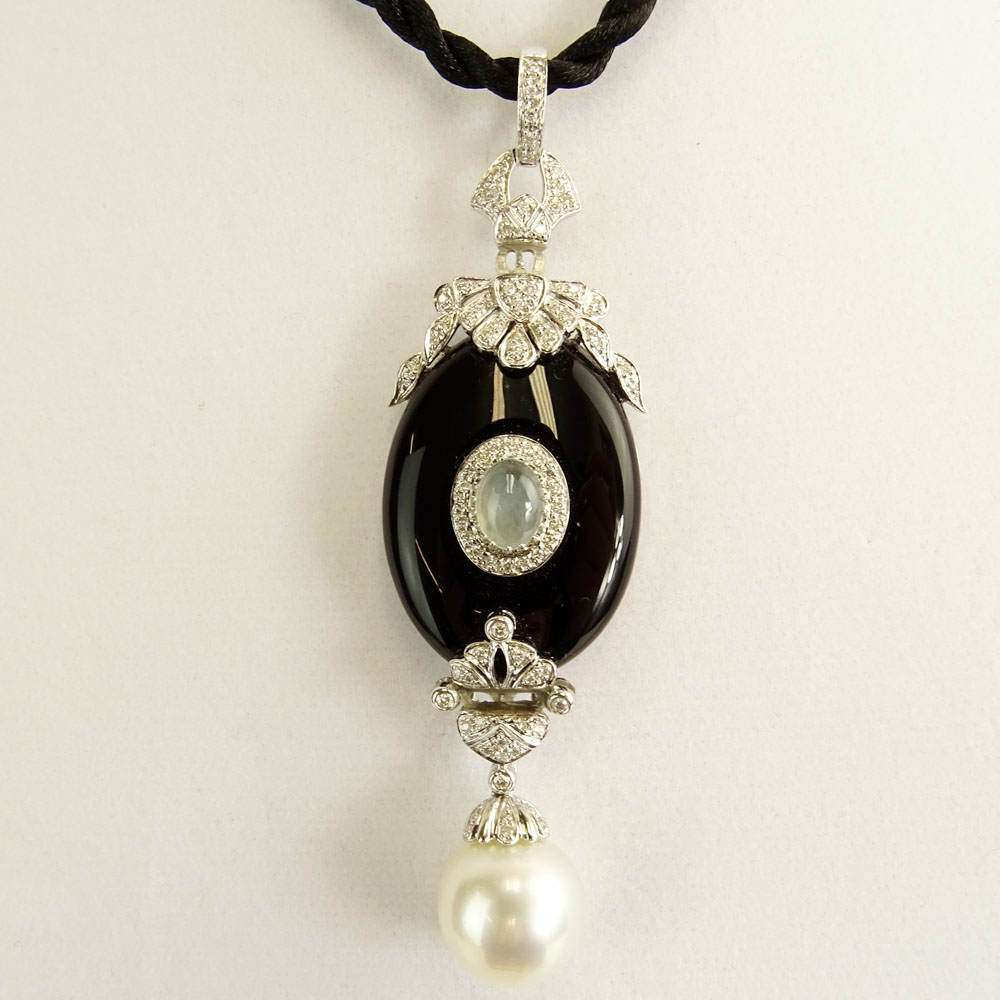 Modern Art Deco style South Sea Pearl, Black Onyx, 18 Karat White Gold Pendant accented with small round cut diamonds. 