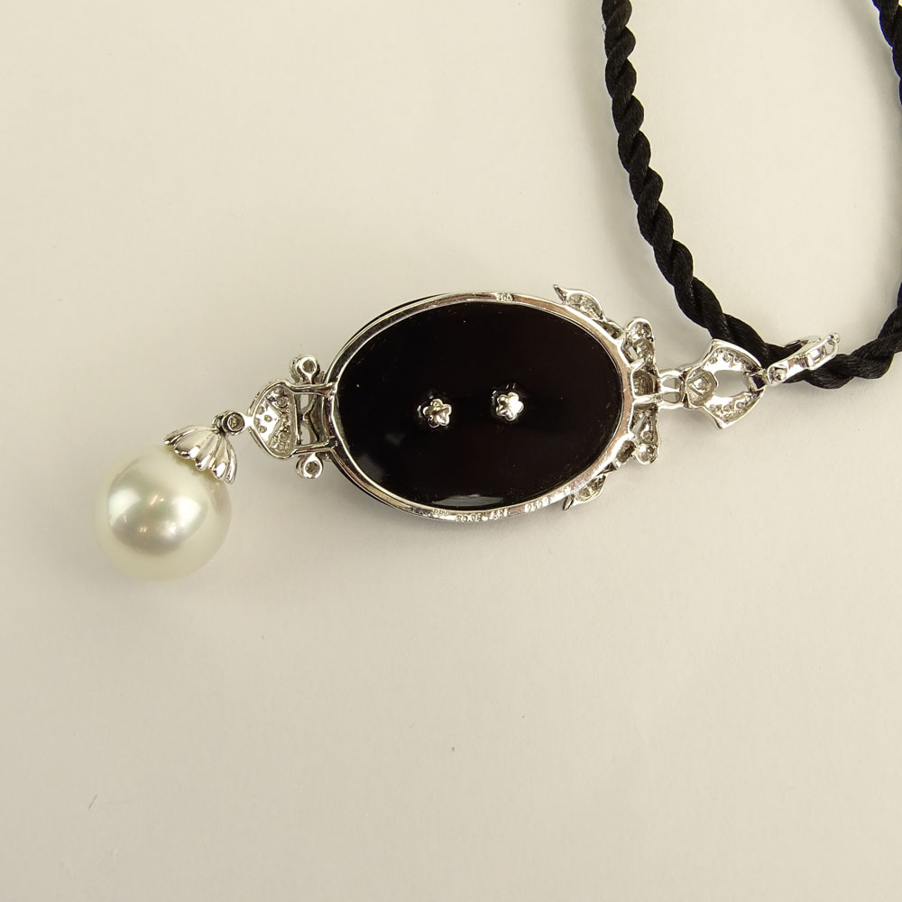 Modern Art Deco style South Sea Pearl, Black Onyx, 18 Karat White Gold Pendant accented with small round cut diamonds. 