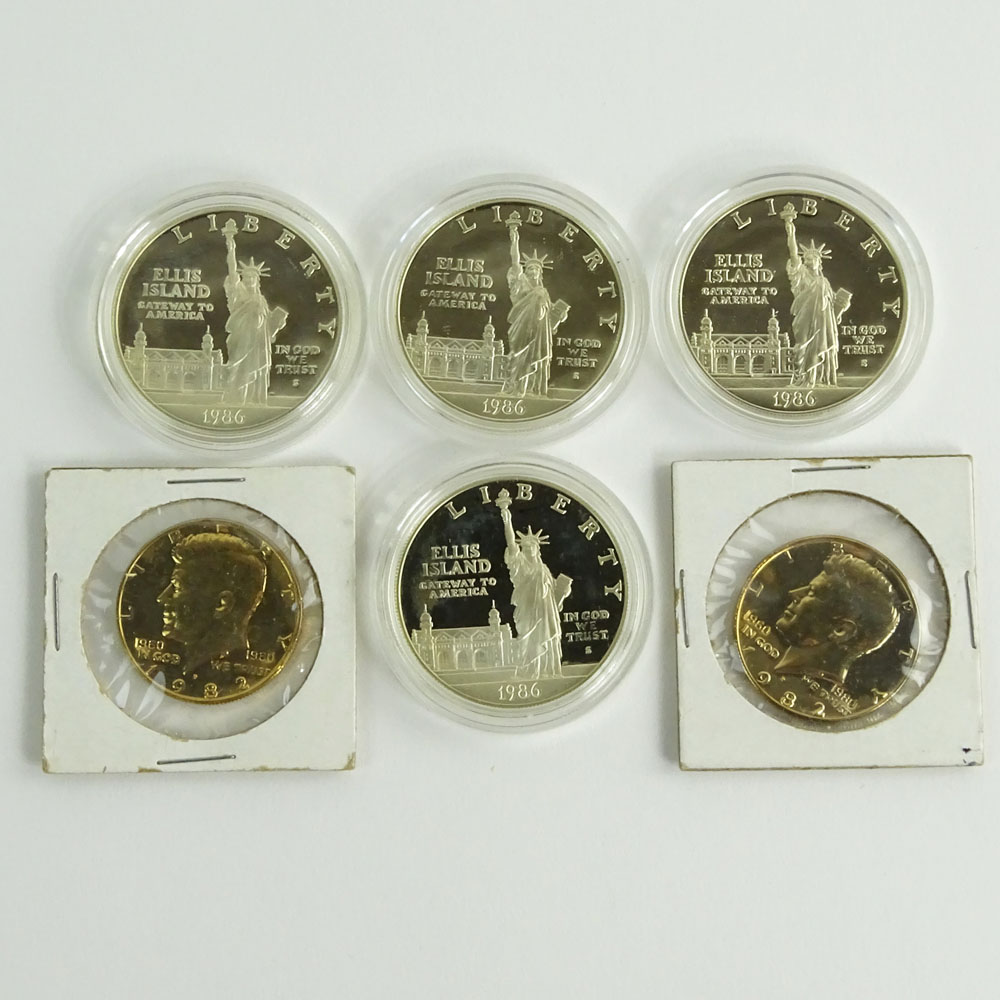 Lot of Four (4) 1986 Ellis Island Commemorative One Dollar Coins and Two (2) 1982 Gold Washed Kennedy Half Dollars.