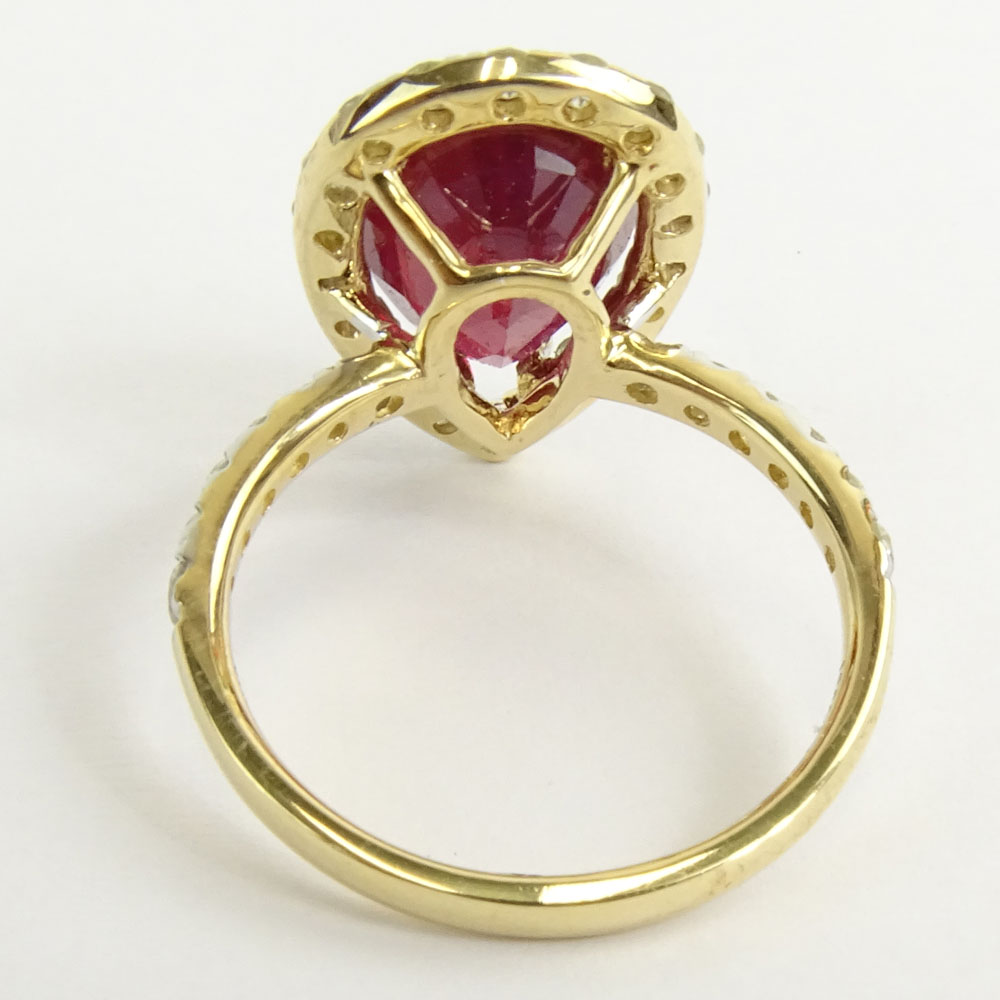 GGA Certified 5.61 Carat Pear Shape Ruby and 14 Karat Yellow Gold Ring Accented with 1.09 Carat Round Brilliant Cut Diamonds.