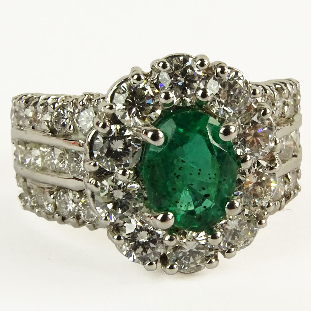 Lady's Oval Cut Emerald,  Round Brilliant Cut Diamond and 14 Karat White Gold Ring. 