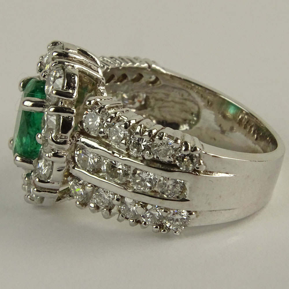 Lady's Oval Cut Emerald,  Round Brilliant Cut Diamond and 14 Karat White Gold Ring. 