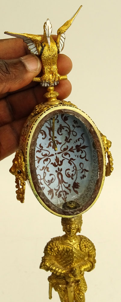 Early 20th Century Vienna Enamel and Gilt Metal Watch Holder. Unsigned. Losses/Damages to finial and to watch holder. Please examine this lot carefully before bidding. Measures 13-1/2" H (without bird finial), 4" W at base. Shipping $48.00 (estimate $500-