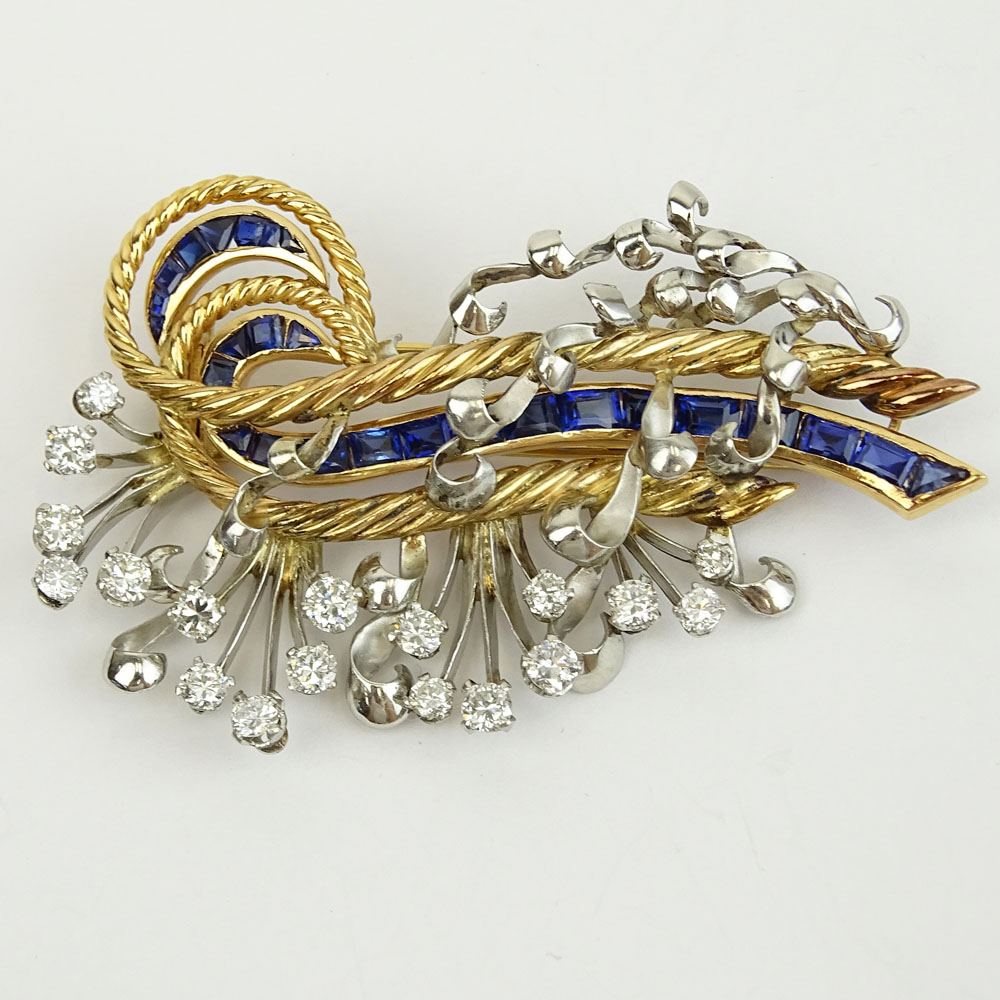 Retro Approx. 2.50 Carat Round Brilliant Cut Diamond, 7.50 Carat Invisible Set Square and Emerald Cut Sapphire, 18 Karat Yellow and White Gold Brooch. 