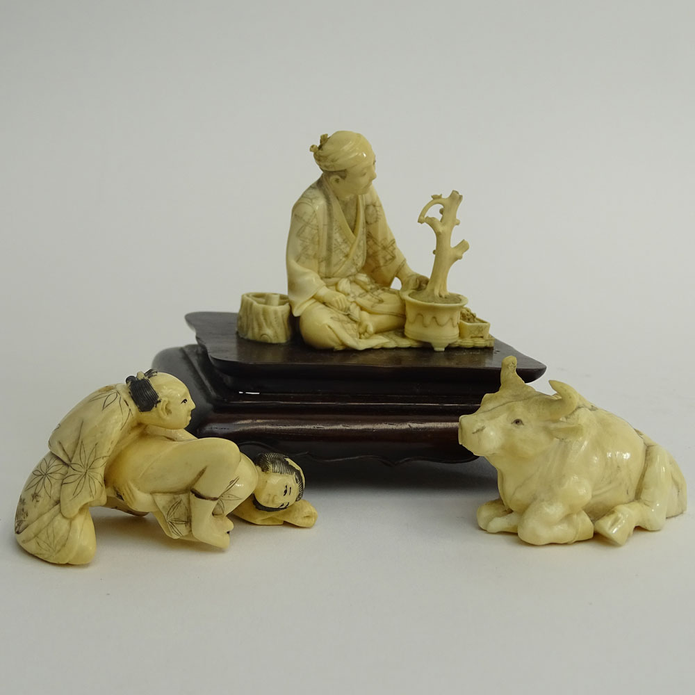 Two (2) Vintage Japanese Carved Ivory Okimono, Seated Man with Bonsai on Wood Base and Water Buffalo and a Japanese Carved Ivory Netsuke Erotic Couple.