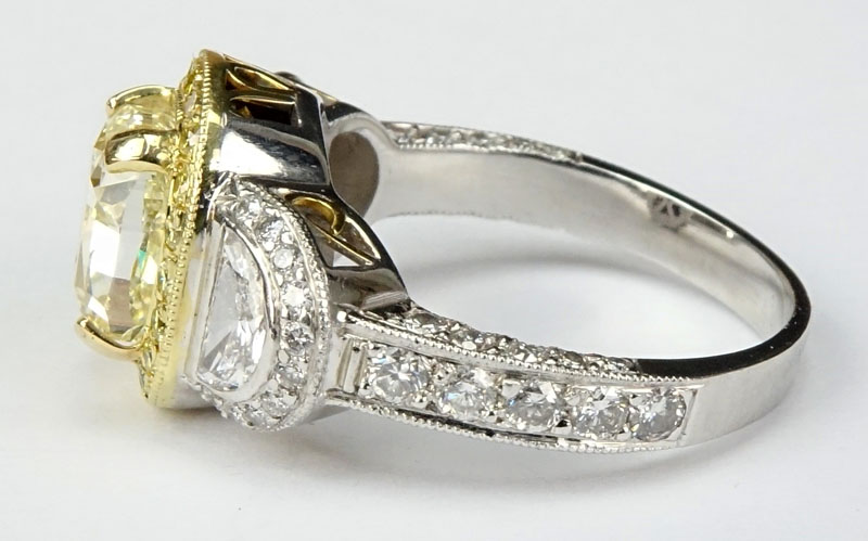 Approx. 3.40 Carat Cushion Cut Fancy Light Yellow Diamond, 1.70 Carat Diamond and Platinum Engagement Ring.