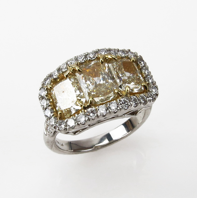 EGL Certified 2.91 Carat Radiant Cut Fancy Light Yellow Diamond and Platinum Three Stone Ring accented throughout with .72 Carat Round Brilliant Cut Diamonds.