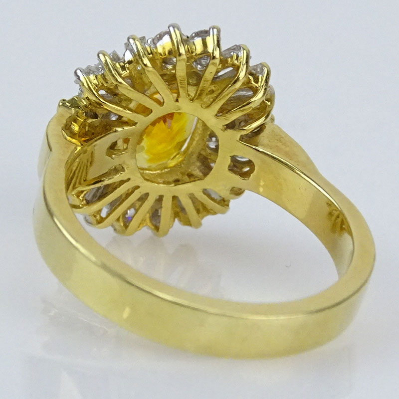 3.89 Carat Oval Cut Orange Sapphire, 1.50 Carat Round Brilliant and Baguette Cut Diamond and 18 Karat Yellow Gold Ring. 