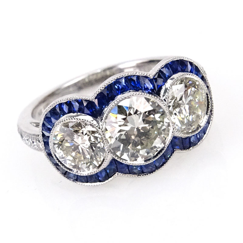 2.67 Carat Round Brilliant Cut Diamond and Platinum Three Stone Ring accented with .88 Carat French Cut Sapphires.