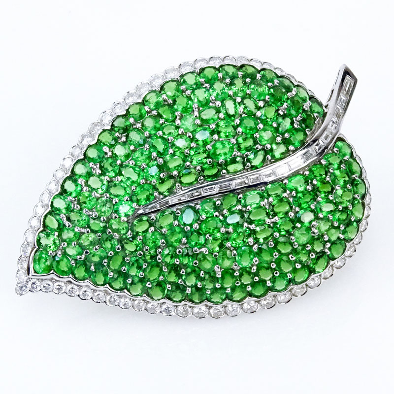  41.06 Carat Oval Cut Tsavorite Garnet, 5.28 Carat Round Brilliant and Tapered Baguette Cut Diamond and 18 Karat White Gold Leaf Brooch. 