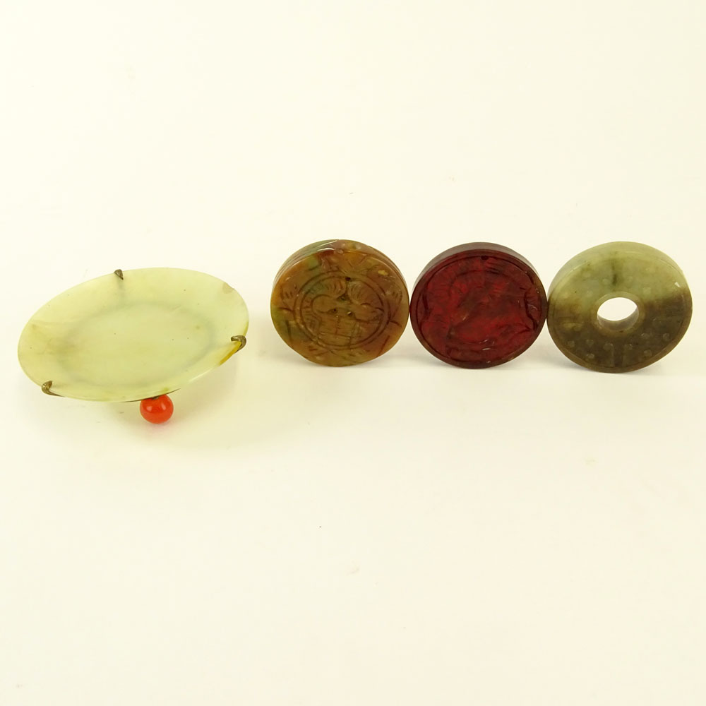 Chinese Archaistic Carved Celadon to Russet Jade Bi Disc; Chinese Carved Russet Jade Pendant Disc; Chinese Carved Blood Red Jade Pendant Disc and a small Chinese Celadon Jade Dish with Carnelian Bead Feet