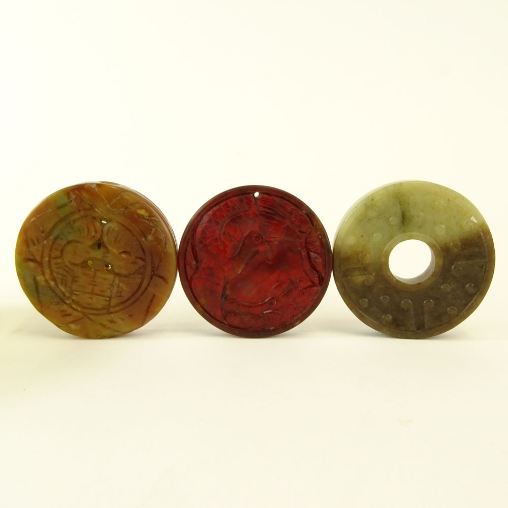 Chinese Archaistic Carved Celadon to Russet Jade Bi Disc; Chinese Carved Russet Jade Pendant Disc; Chinese Carved Blood Red Jade Pendant Disc and a small Chinese Celadon Jade Dish with Carnelian Bead Feet