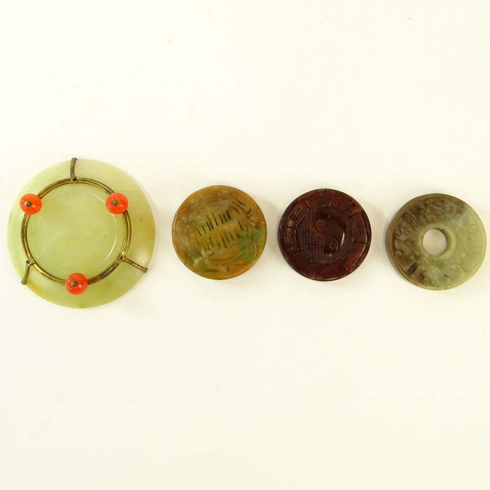 Chinese Archaistic Carved Celadon to Russet Jade Bi Disc; Chinese Carved Russet Jade Pendant Disc; Chinese Carved Blood Red Jade Pendant Disc and a small Chinese Celadon Jade Dish with Carnelian Bead Feet