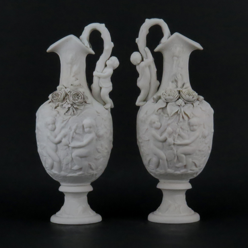 Pair of Victorian Style Bisque Porcelain Putti Figural Relief Ewers