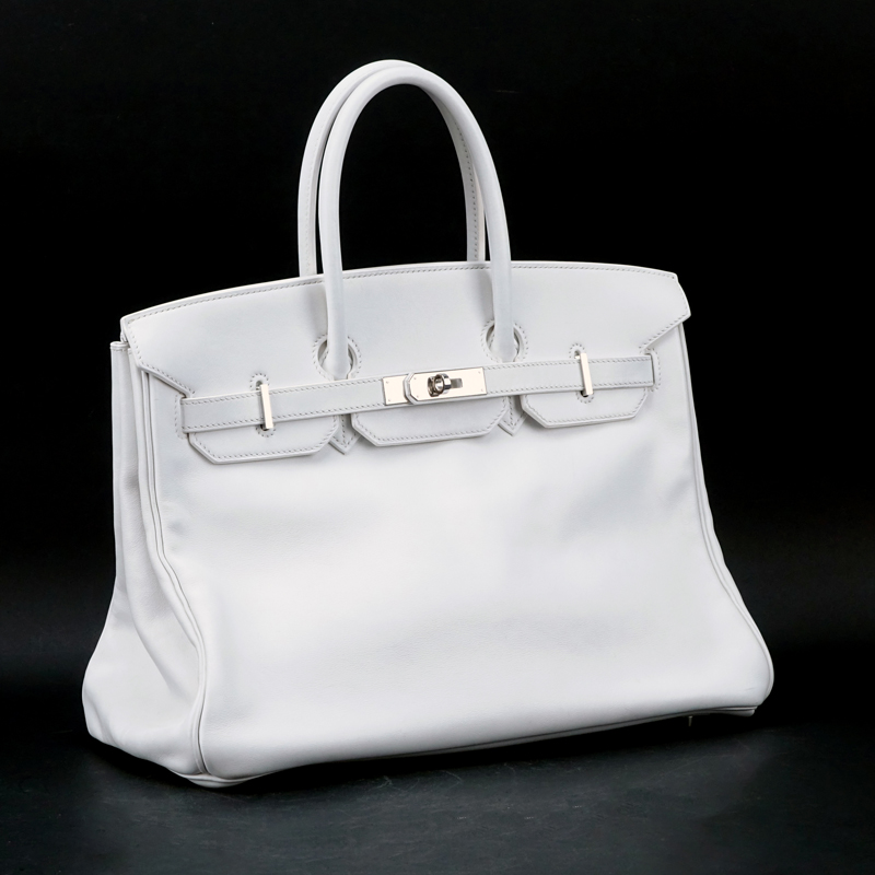 Hermès White Swift Leather Birkin 35 Bag. Palladium hardware. Interior with zipper and slot pocket. Clochette, keys and lock included as well as dust bag. 