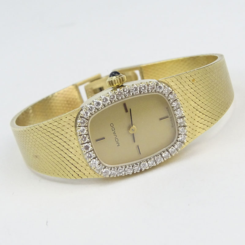 Lady's Vintage Movado 14 Karat Yellow Gold Bracelet watch with Diamond Bezel and with Swiss 17 Jewel Zenith Manual Movement.