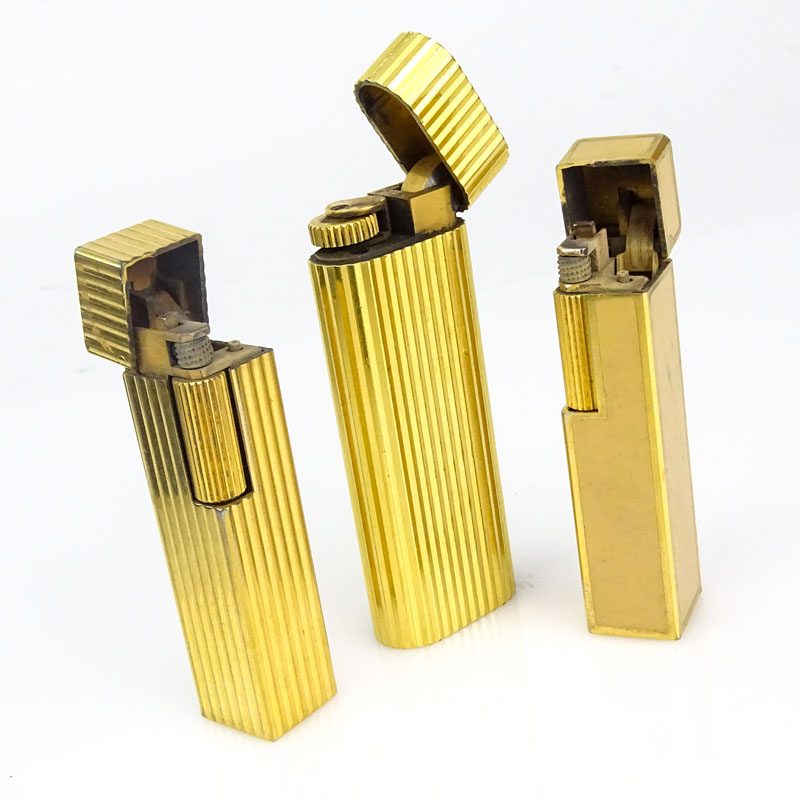 Three (3) Vintage Cartier Gold Plate Butane Cigarette Lighters, One with Lacquer. 