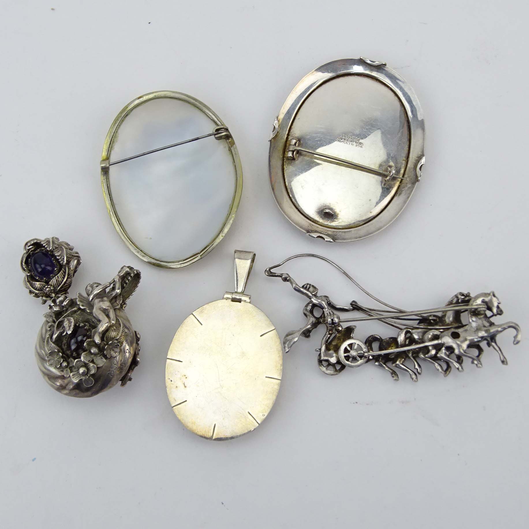 Art Nouveau style Sterling Silver Pendant Scent/Snuff Bottle with Amethyst and Garnet Accents; 935 Silver and Marcasite Chariot Brooch; English Sterling Silver Brooch Frame; American 950 Silver and Onyx Pendant and Russian Painted Shell Brooch.