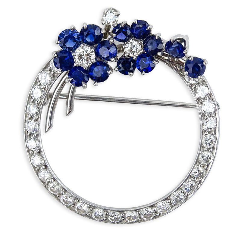 Vintage Approx. 1.0 Carat Round Brilliant Cut Diamond, Sapphire and 18 Karat White Gold Circle Brooch. Diamonds H color, VS1 clarity. Sapphires with vivid saturation of color. 