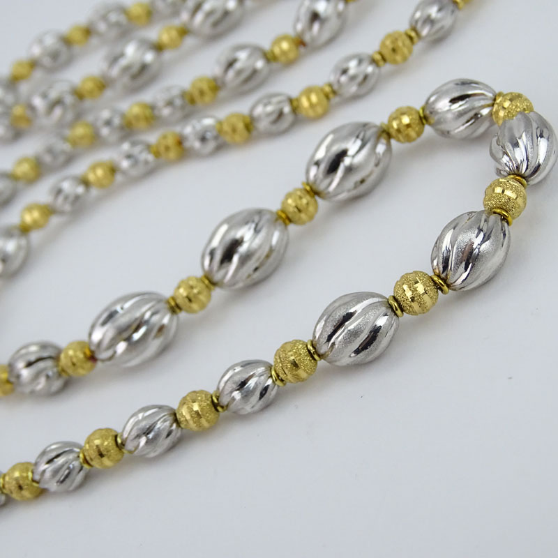 Long Single Strand 18 Karat Yellow and White Gold Graduated Bead Necklace.