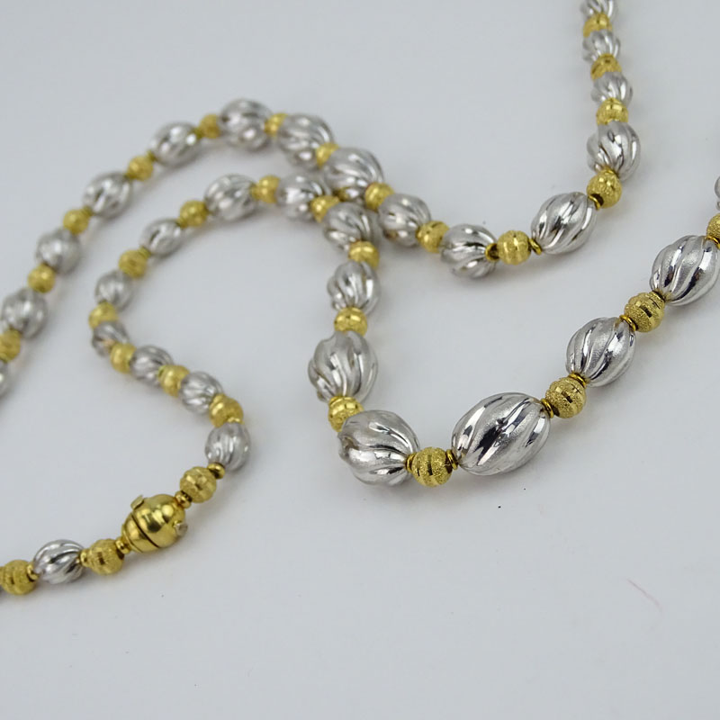 Long Single Strand 18 Karat Yellow and White Gold Graduated Bead Necklace.