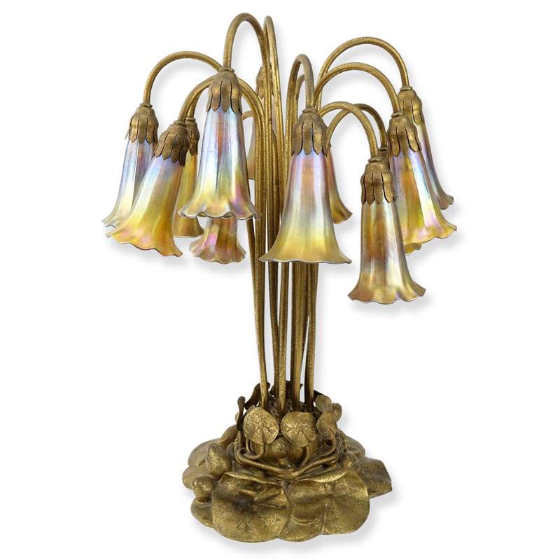 Important Tiffany Studios Twelve-Light Pond Lily Lamp. The pond lily base of dore bronze, the drop cluster blossom design shades in iridescent favrile glass. 