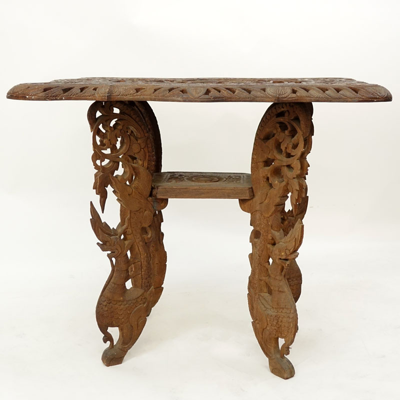 20th Century Thai Carved Teak Wood Table. Relief carving to top, pierced border, and stands on dragon figural legs. 