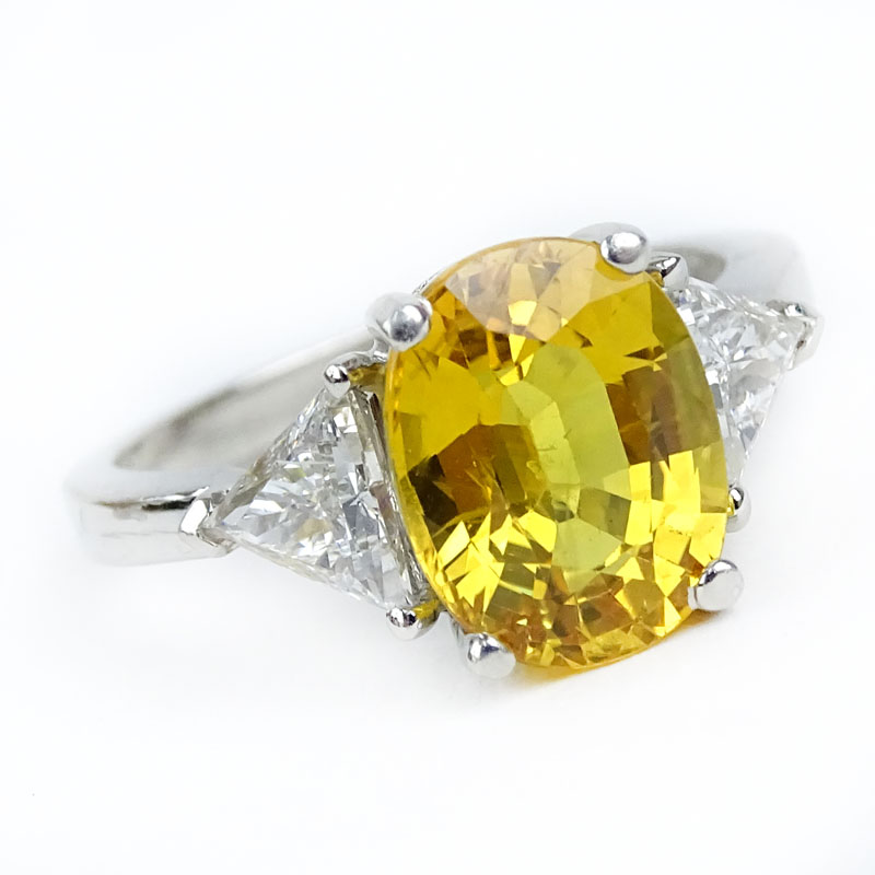 Approx. 4.33 Carat Oval Cut Yellow Sapphire, .78 Carat Trillion Cut Diamond and Platinum Ring. 