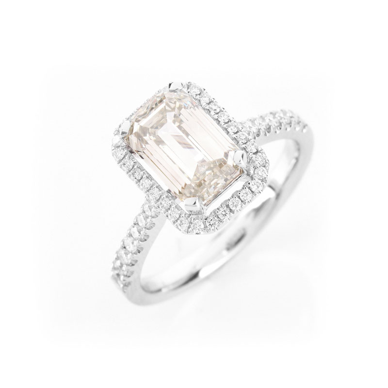 Approx. 2.10 Carat Emerald Cut Diamond and 18 Karat White Gold Engagement Ring accented throughout with Round Brilliant Cut Diamonds.