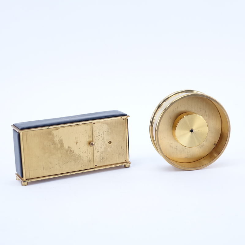 Two Brass Clocks. A Tiffany & Co. round quartz clock, inscribed "To Jay From Normie 12-11-81"; a Saks brass and leather Swiss desk clock with temperature and barometer. 