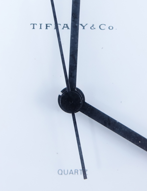Two Brass Clocks. A Tiffany & Co. round quartz clock, inscribed "To Jay From Normie 12-11-81"; a Saks brass and leather Swiss desk clock with temperature and barometer. 