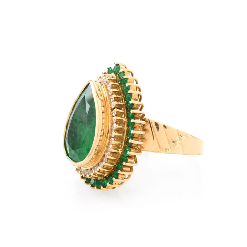 Approx. 7.50 Carat Pear Shape Colombian Emerald and 18 Karat Yellow Gold Ring accented with .50 Carat Round Brilliant Cut Diamonds and 2.0 Carat Round Cut Emeralds.