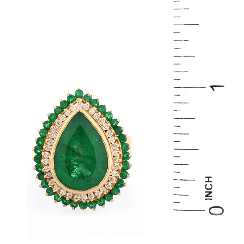 Approx. 7.50 Carat Pear Shape Colombian Emerald and 18 Karat Yellow Gold Ring accented with .50 Carat Round Brilliant Cut Diamonds and 2.0 Carat Round Cut Emeralds.