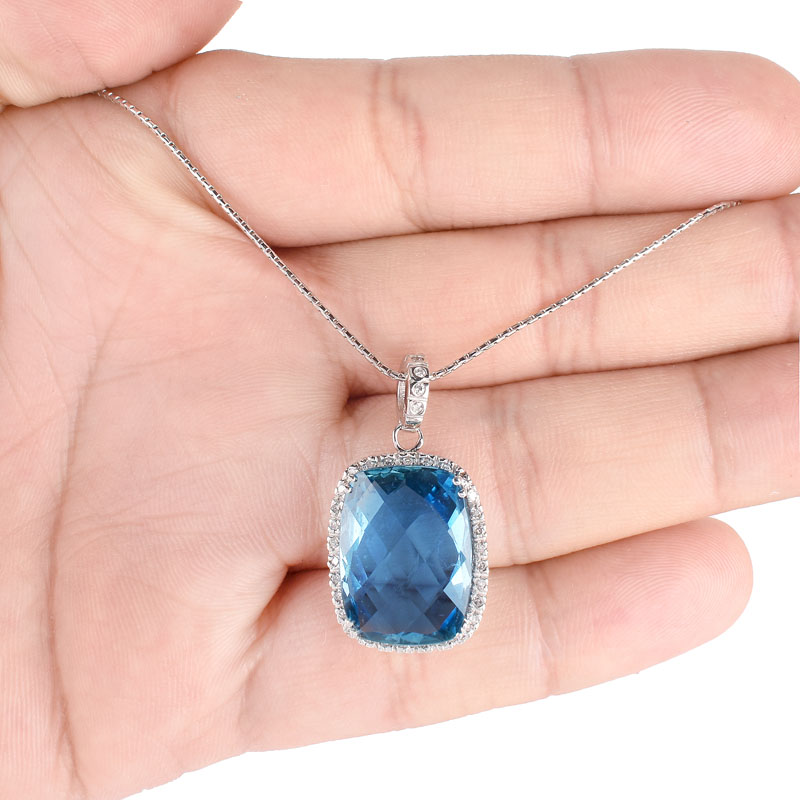 Criss Cross Cut London Blue Topaz, Diamond and 14 Karat White Gold Pendant Necklace. Topaz measures 18mm x 13mm. 