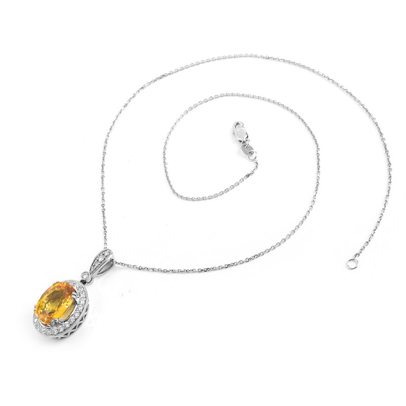 Approx. 6.52 Carat Oval Cut Yellow Sapphire, .65 Carat Pave Set Diamond and 18 Karat White Gold Pendant with 14 Karat White Gold Chain.