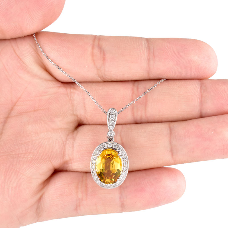 Approx. 6.52 Carat Oval Cut Yellow Sapphire, .65 Carat Pave Set Diamond and 18 Karat White Gold Pendant with 14 Karat White Gold Chain.