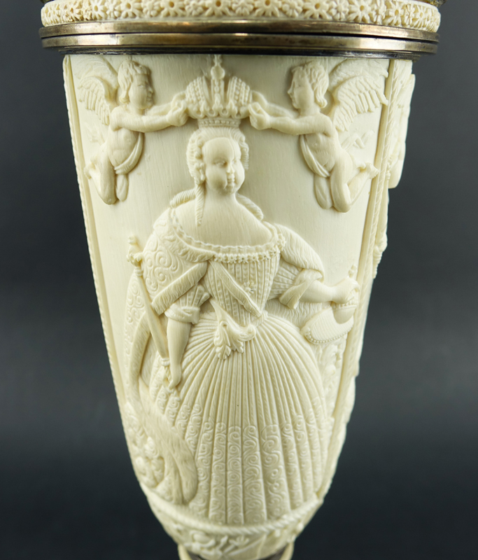 Impressive Early 19th Century Russian Imperial Carved Ivory And Silver Mounted Figural Vase And Cover. The circular base  with male figures supporting a tapered cylindrical vase carved in relief with Peter The Great and Anna Ioannovna.