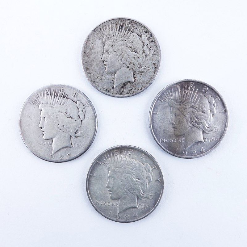 Group of Four: 1922-1924 U.S Silver Peace Dollars. Two with mint marks.