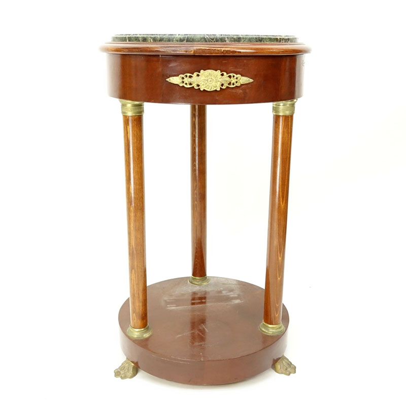 20th Century Empire Style Round Marble Top Table. Gilt brass mounted with four columns and stands on paw feet.