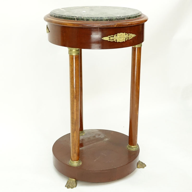 20th Century Empire Style Round Marble Top Table. Gilt brass mounted with four columns and stands on paw feet.