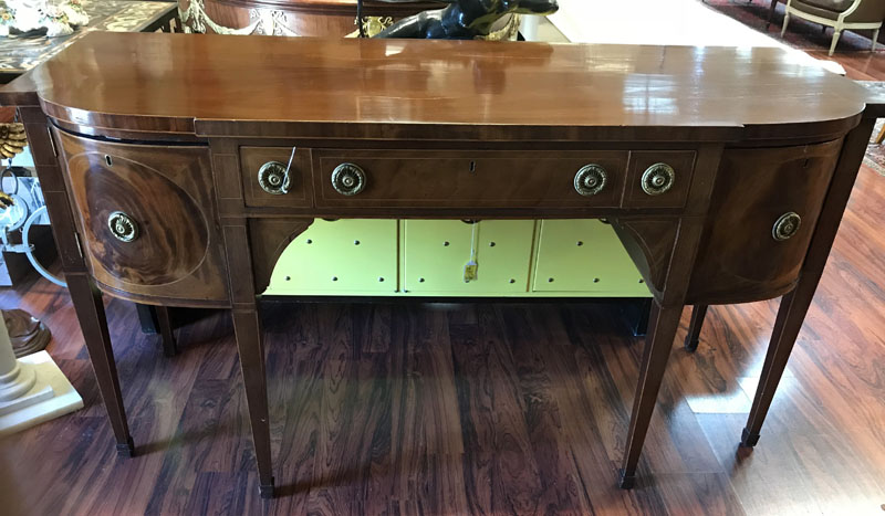 Antique Sheraton Flame Mahogany Sideboard. Center has fitted wide drawer, a pair of sliding doors, large deep drawers and large sliding drawer all with brass pulls, stands on high tapering legs, missing key.