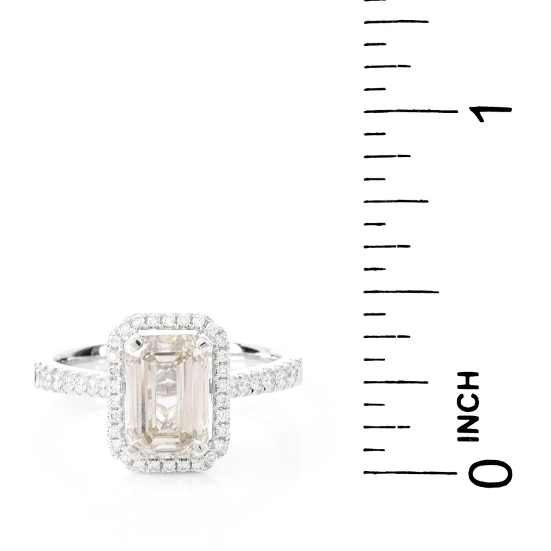 Approx. 2.10 Carat Emerald Cut Diamond and 18 Karat White Gold Engagement Ring accented throughout with Round Brilliant Cut Diamonds.