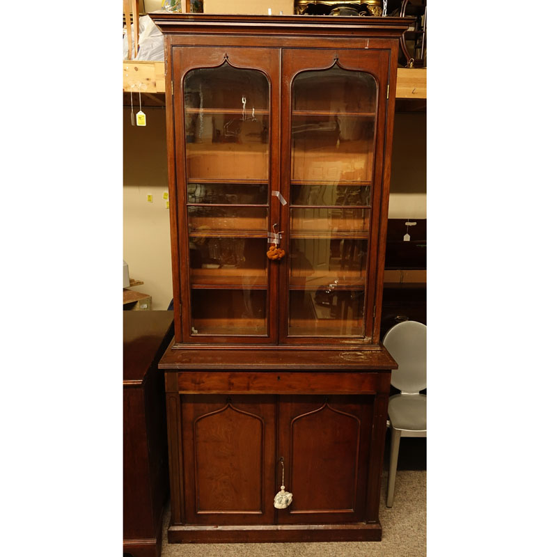 Antique Victorian Mahogany Bookcase. Two large glass display doors with gothic arches at the top, large fitted center drawer above two doors, key included.
