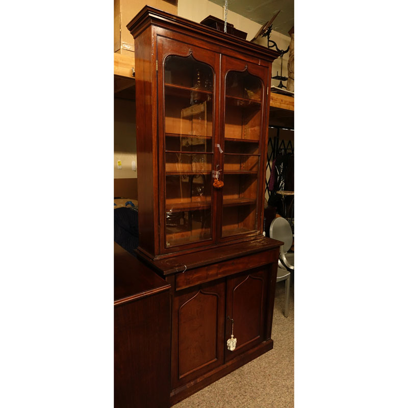 Antique Victorian Mahogany Bookcase. Two large glass display doors with gothic arches at the top, large fitted center drawer above two doors, key included.